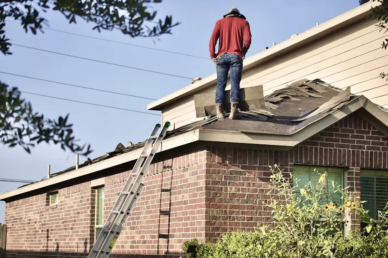 Professional roofer working on a residential roof in Erma